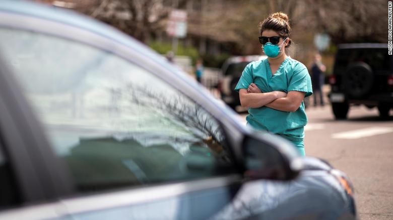 Health care workers stand in the street in counter-protest to hundreds of people who gathered at the State Capitol to demand the stay-at-home order be lifted in Denver, Colorado, U.S. April 19, 2020. REUTERS/Alyson McClaran MANDATORY CREDIT. NO RESALES. NO ARCHIVES